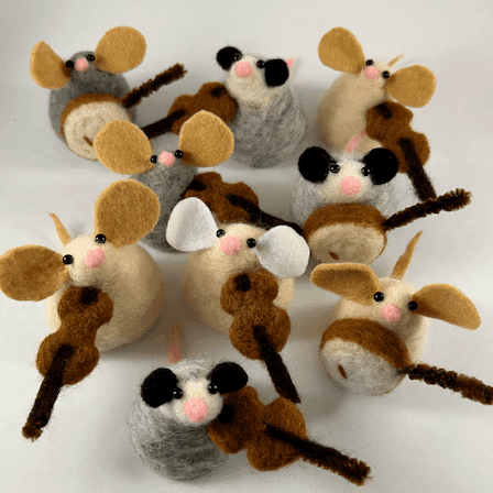 Needle-felted mice and possums look up at the camera from inside a lightbox. They are playing banjos and fiddles made of wool and pipe cleaners.