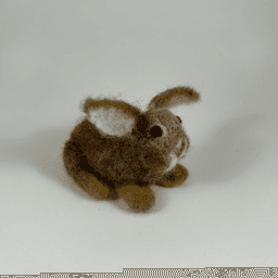 A needle-felted Eastern cottontail rabbit faces 3/4 towards the right. Its ears are splayed widely, showing the lighter colored undersides of the ears. Its cheeks are round and its large dark eyes bulbous.