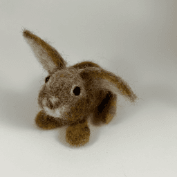 A needle-felted Eastern cottontail rabbit faces 1/4 towards the left, showing its rounded paws.