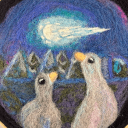 Close up within the 8 inch frame of wool painting of two ducks watching a meteor in the night sky, the light reflected in their awe-filled eyes. There are trees in the background. The duck on the left is darker with purple highlights, while the duck on the right is lighter with pink and light blue highlights.
