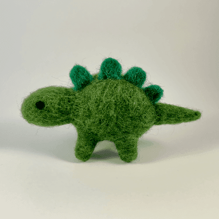 A needle-felted green stegasaurus faces directly towards the left.