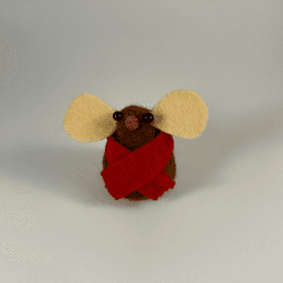 A needle-felted chocolate colored mouse wearing a red scarf facing towards the camera.