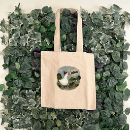 Canvas bag depicting a wizard goose honking hanging on a back drop of artificial ivy.