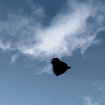 A silhouette of a needle-felted black-capped chickadee borb flies mid-air across a beautiful summer morning blue sky with wispy clouds.