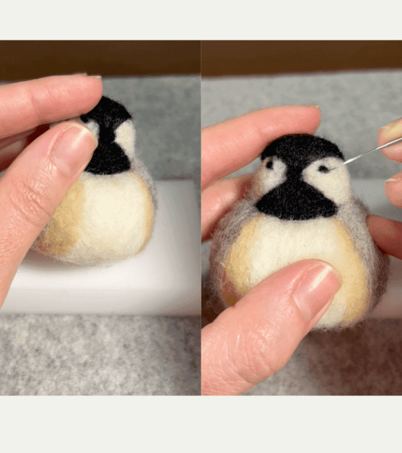 On the left side of the image, a partially obscured left hand places a tiny black ball of fiber on the face of a needle-felted chickadee-in-progress which sits on a felting pad. On the right side, a partially obscured left hand holds the chickadee-in-progress while a mostly obscured right hand pokes in a right eye in its face with a felting needle.