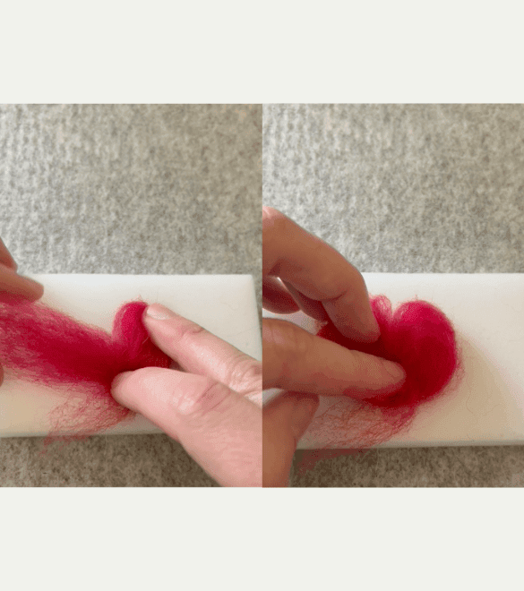 On the left side of the image, two partially obscured hands shape some red felting wool on a felting pad. The right hand's two fingers have curled half the wool into a half heart, and the left hand pulls the other half of the wool. On the right side, the left hand holds the wool in place on the mat, loosely shaped into a heart.